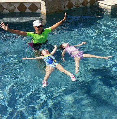 children floating in swim pool