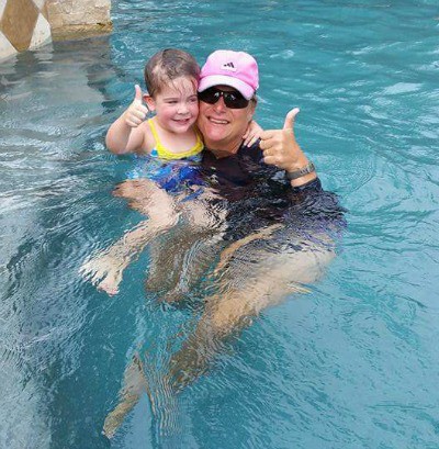 instructor teaching swimming to child